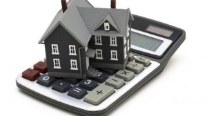 House sitting on calculator isolated on white